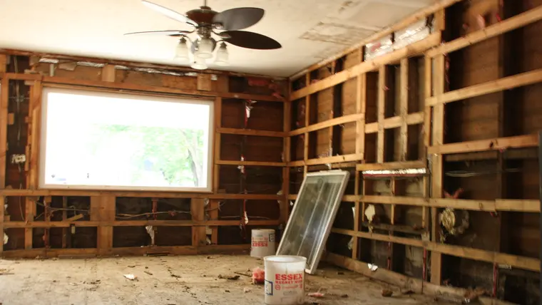 Room with wet flooring and drywall removed for drying
