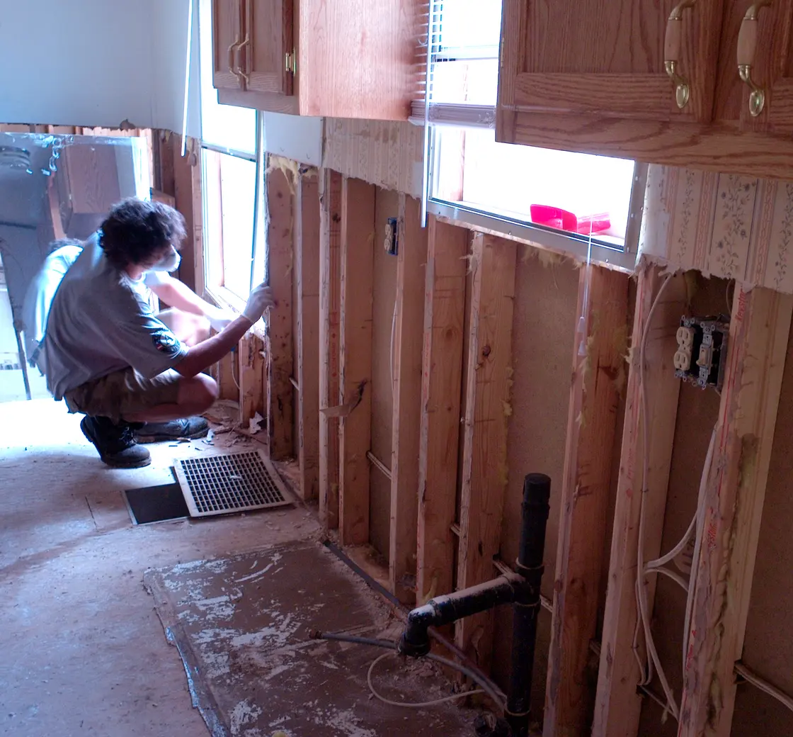 Kitchen with water-damaged walls opened up around the plumbing