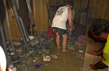 Worker clearing contaminated debris from a flooded lower level