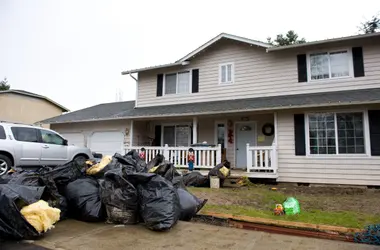 Flood-damaged belongings bagged at the curb after a storm