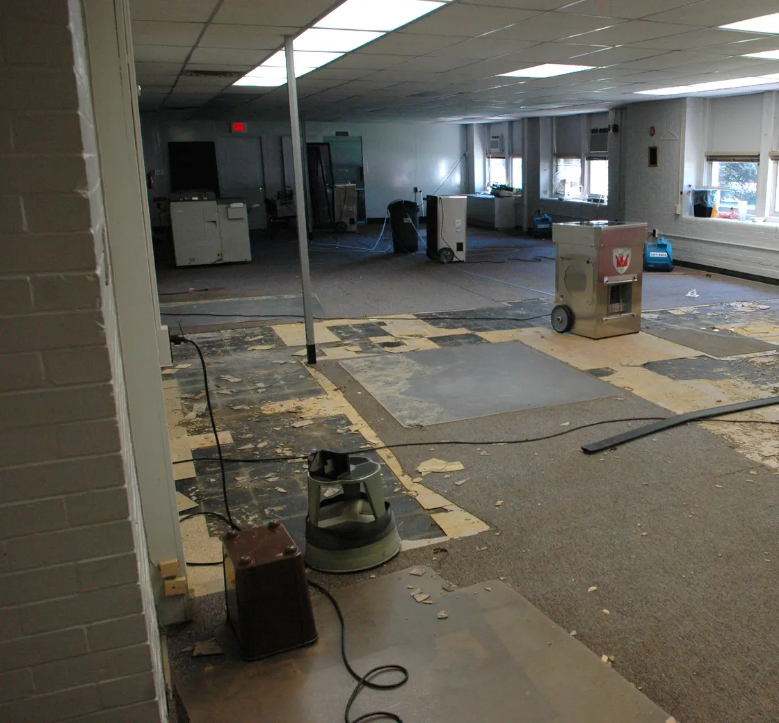 Dehumidifiers drying a large commercial room after flooding