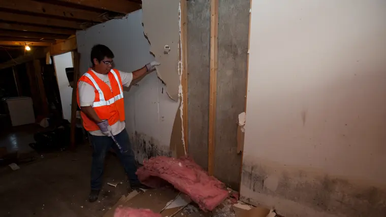 Wet drywall being removed from a finished basement